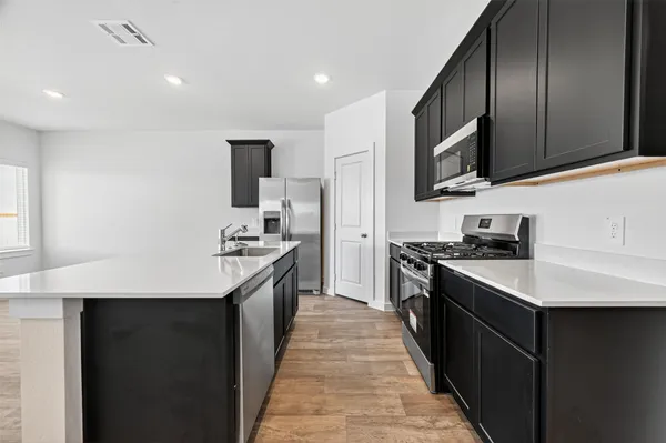 a kitchen with stainless steel appliances a stove microwave and refrigerator