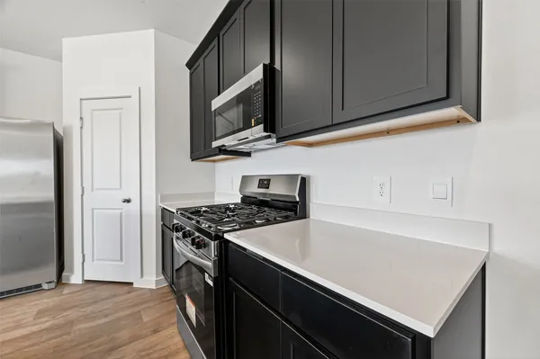 a kitchen with stainless steel appliances granite countertop a sink a refrigerator and a stove