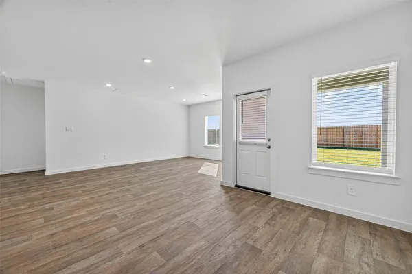 a view of empty room with wooden floor and fireplace