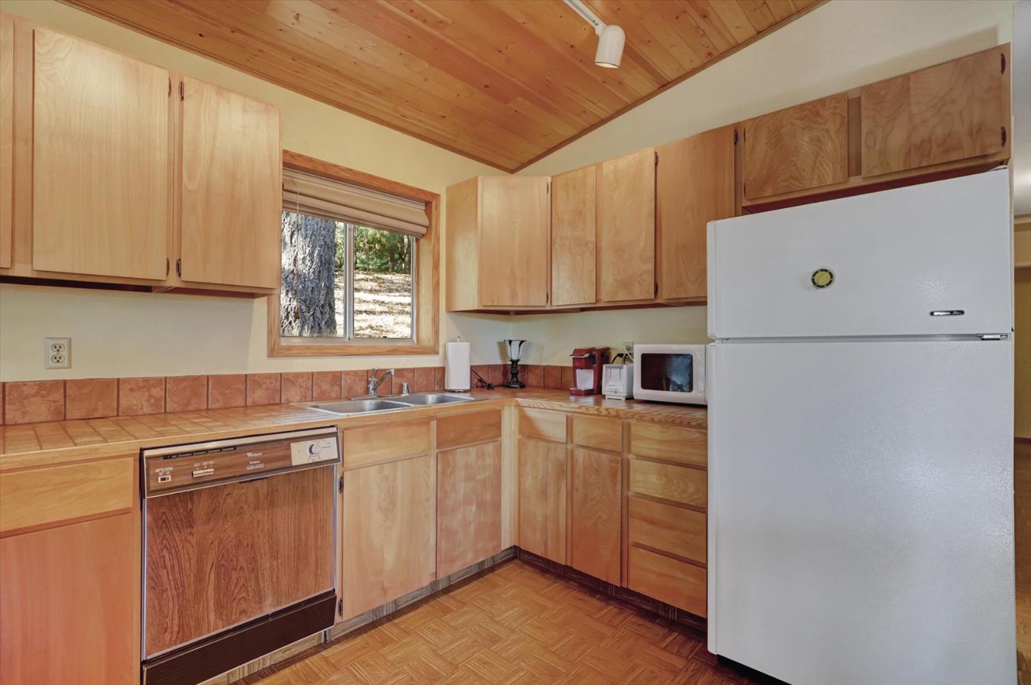 17028 Banner Quaker Hill Road Nevada City, CA 95959 - Photo 16 of 79 a kitchen with cabinets appliances a sink and a window