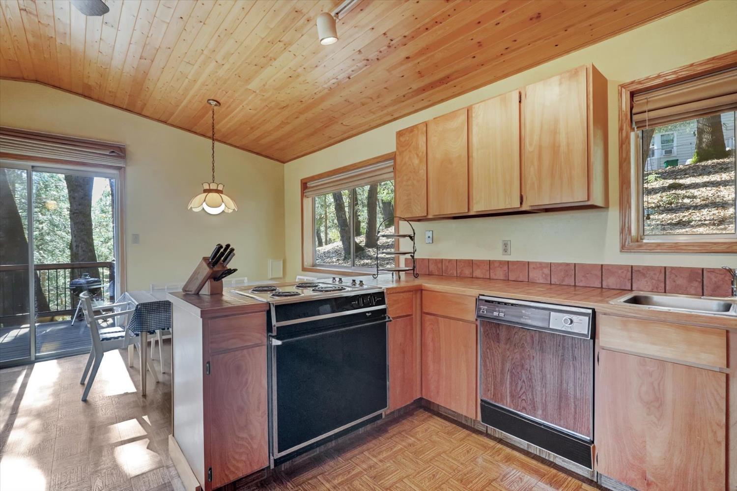 17028 Banner Quaker Hill Road Nevada City, CA 95959 - Photo 17 of 79 a kitchen with stainless steel appliances granite countertop a stove a sink dishwasher and cabinets with wooden floor
