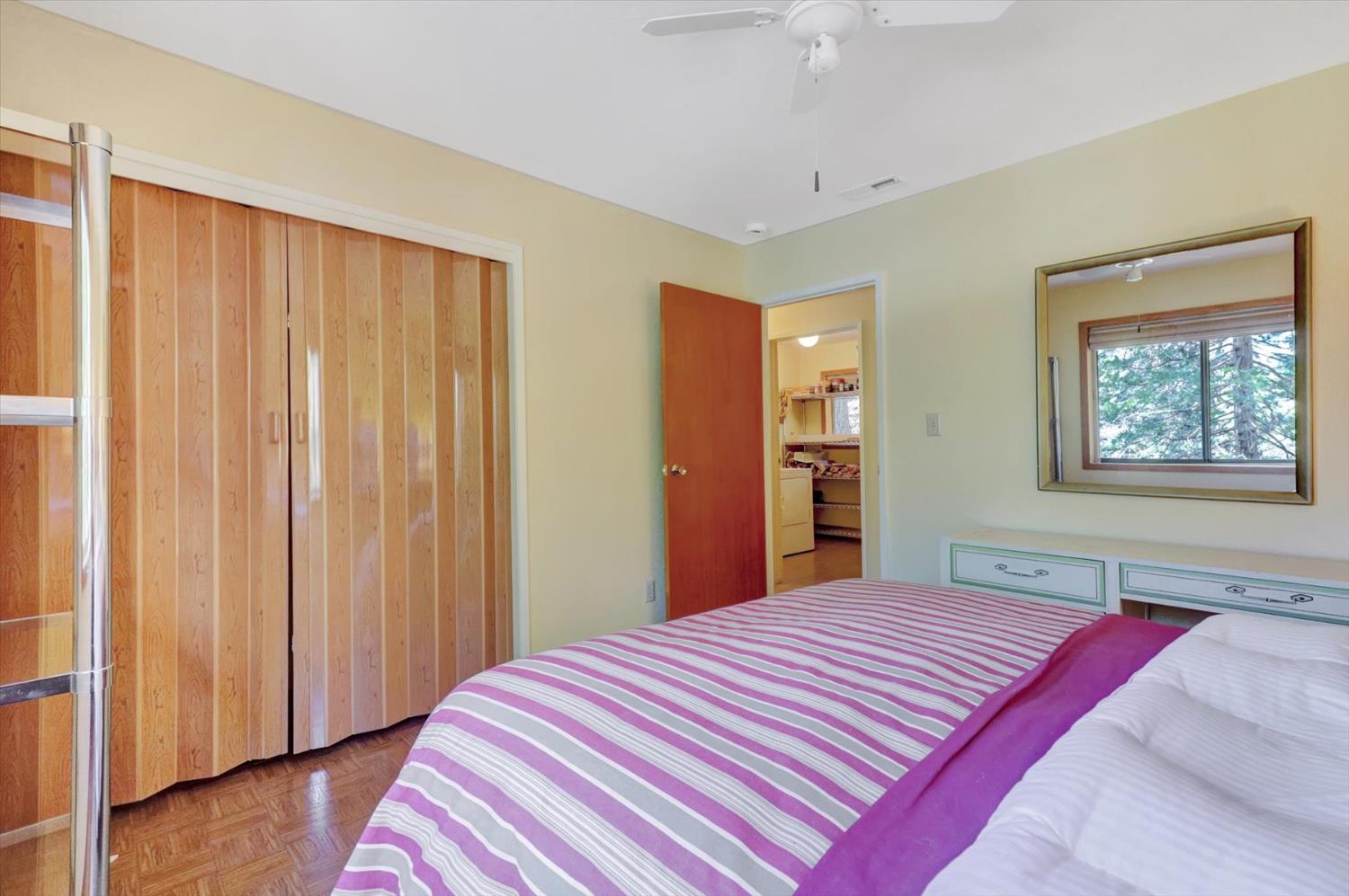 17028 Banner Quaker Hill Road Nevada City, CA 95959 - Photo 32 of 79 a bedroom with a large bed and a chandelier