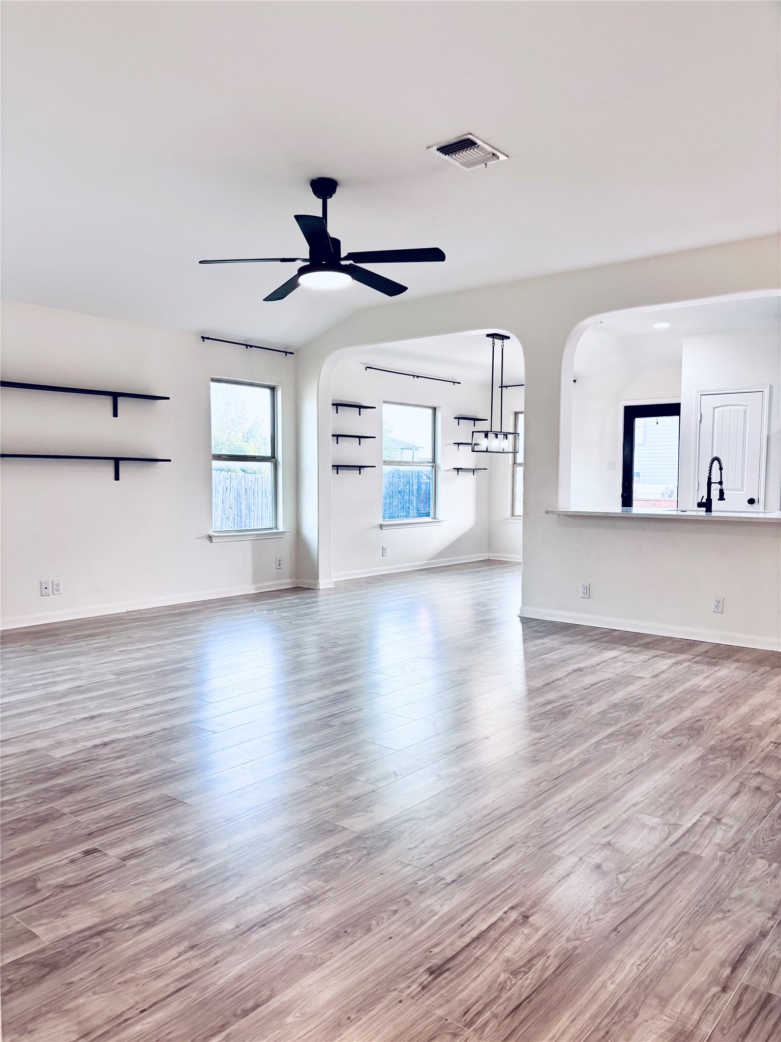 606 Old Peak Road Georgetown, TX 78626 - Photo 10 of 23 Vast open-concept living space features light wood flooring and arched doorways leading to additional rooms.