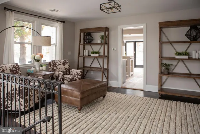 a living room with furniture floor to ceiling window and wooden floor