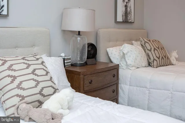 a bedroom with a bed and a lamp on dresser