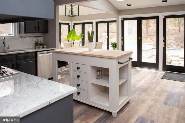 a kitchen with a stove a sink a window and a dining table