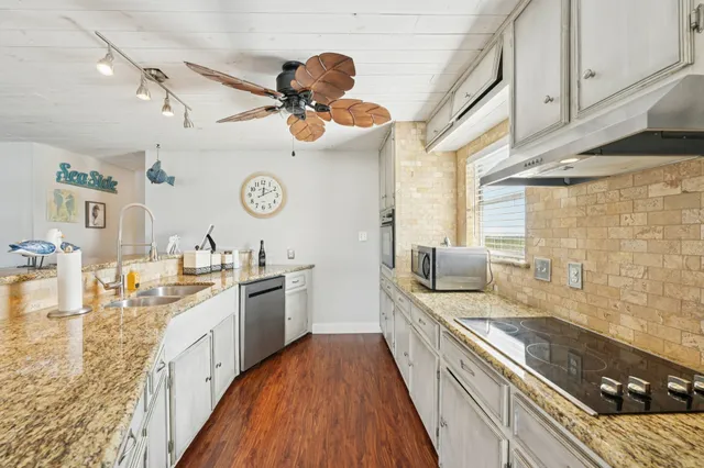 a large kitchen with a stove and a wooden floor