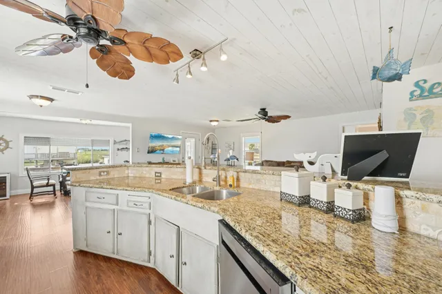 a kitchen with a sink and living room view