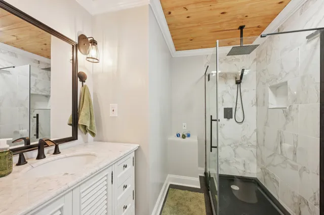 a bathroom with a granite countertop sink mirror and shower