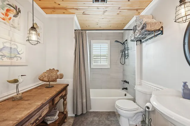 a bathroom with a granite countertop sink a toilet and bathtub
