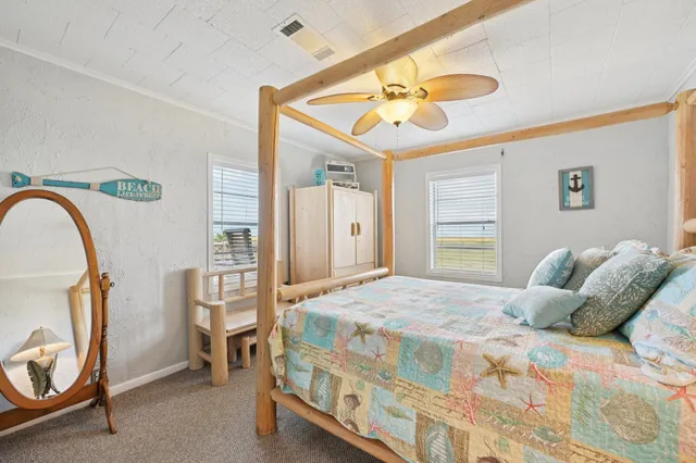 a bedroom with a bed a chandelier and dresser