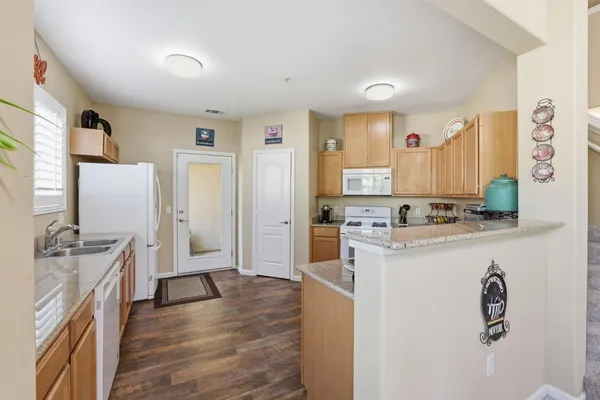 a living room with stainless steel appliances kitchen island granite countertop a stove and a refrigerator