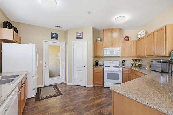 a kitchen with granite countertop a refrigerator stove top oven and sink