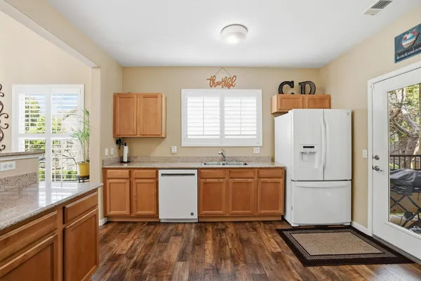 a kitchen with granite countertop a refrigerator stove top oven and sink