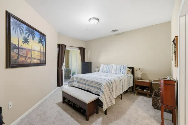 a bedroom with a bed and a flat tv screen on dresser