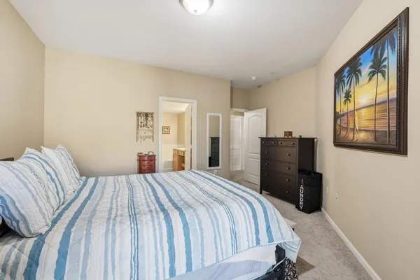 a bedroom with a bed and a painting on the wall