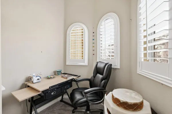 a view of a workspace room with furniture and window