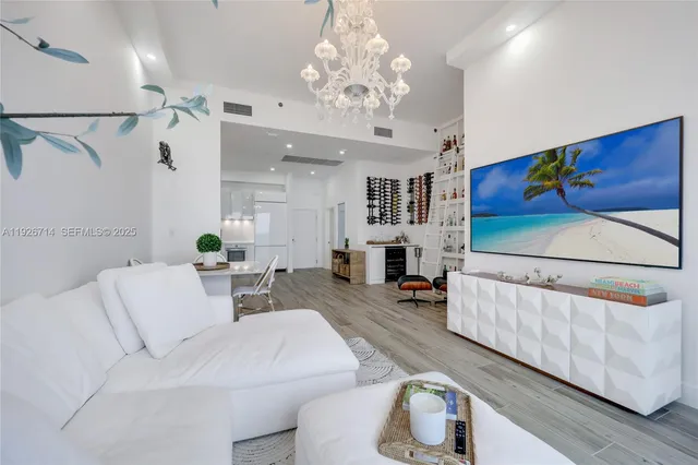a living room with furniture and a chandelier