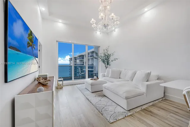 a living room with furniture and a chandelier