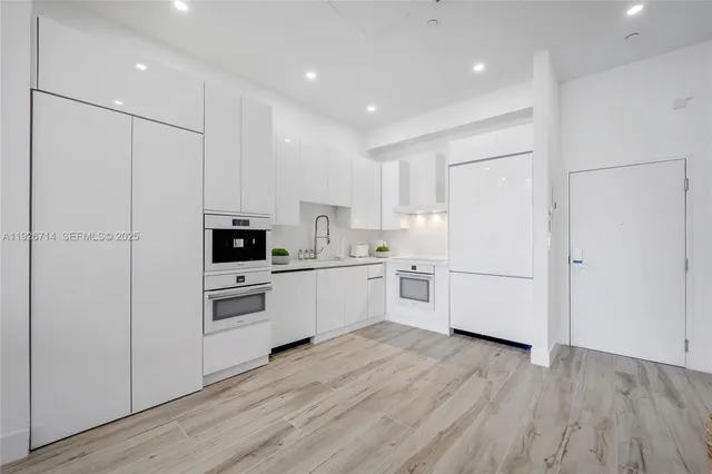 a kitchen with white cabinets and white appliances