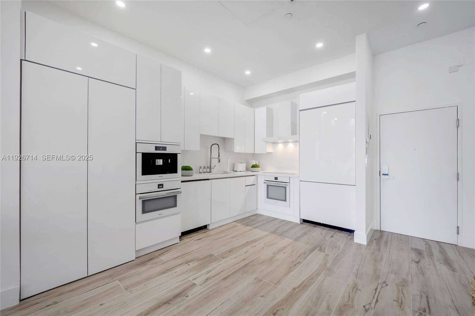 2301 Collins Avenue, Unit 1625 Miami Beach, FL 33139 - Photo 5 of 19 a kitchen with white cabinets and white appliances