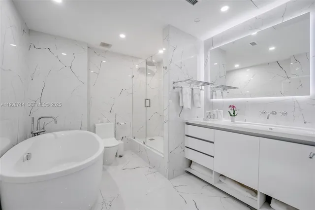 a bathroom with a bathtub a sink a toilet and a shower
