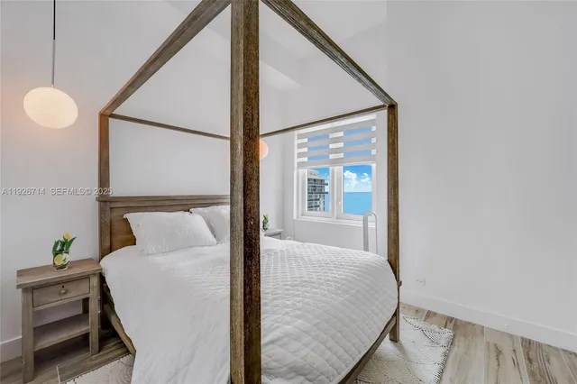 a bedroom with a bed and a large window