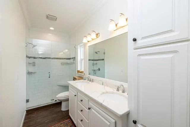 a bathroom with a double vanity sink mirror and toilet