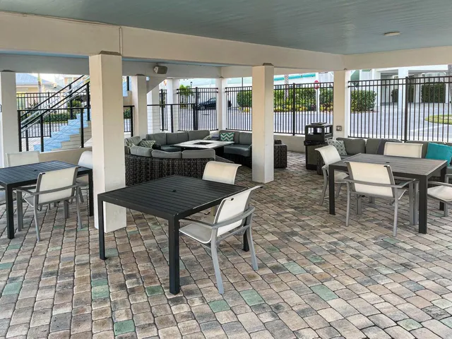 a dining room with furniture and large windows