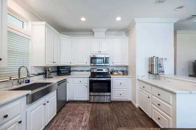 a kitchen with granite countertop white cabinets and white appliances