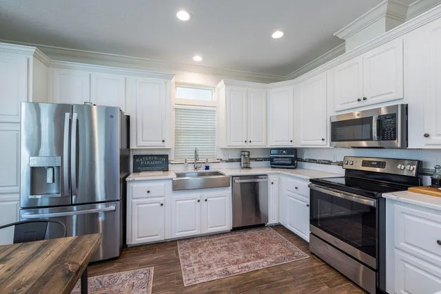 a kitchen with granite countertop a refrigerator stove and microwave
