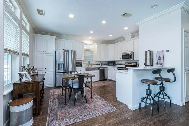 a kitchen with a dining table chairs and refrigerator