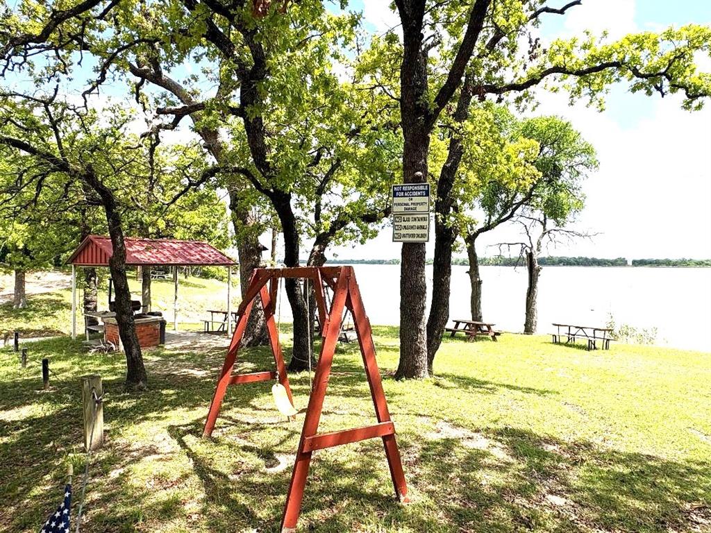 7060 Jay Lane Azle, TX 76020 - Photo 32 of 36 Covered picnic area with charcoal grill for cooking! Shaded swing set & more tables; Stunning lake View!