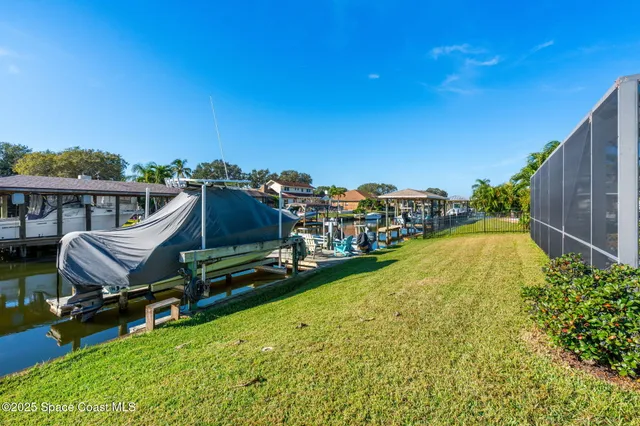 a view of a swimming pool with lawn chairs and a yard