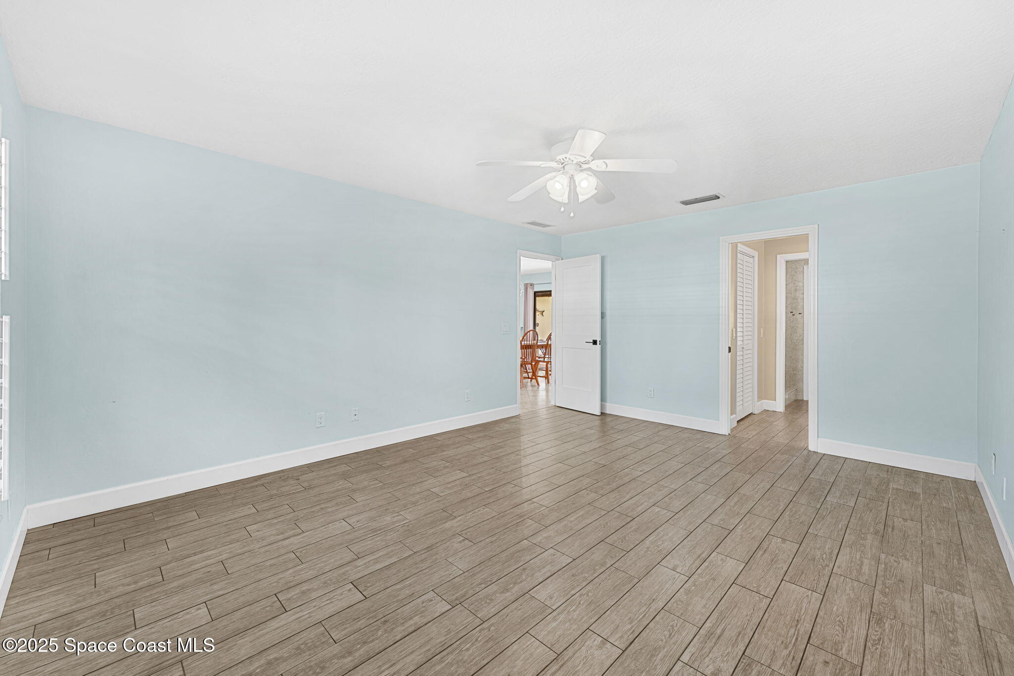 615 Mark And Randy Drive Satellite Beach, FL 32937 - Photo 19 of 40 a view of empty room with wooden floor and ceiling fan
