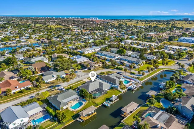 an aerial view of residential houses with outdoor space and parking