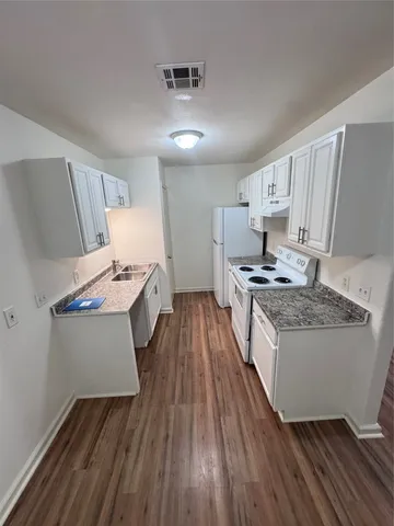 a kitchen with white cabinets and white appliances