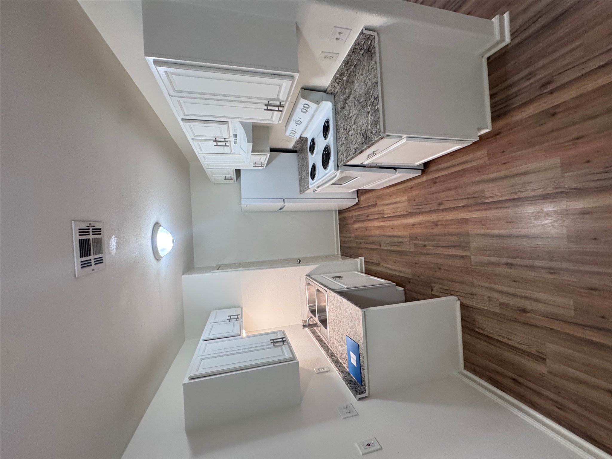 8207 Sam Rayburn Drive, Unit 204 Austin, TX 78753 - Photo 9 of 27 a kitchen with wooden floors and a stove