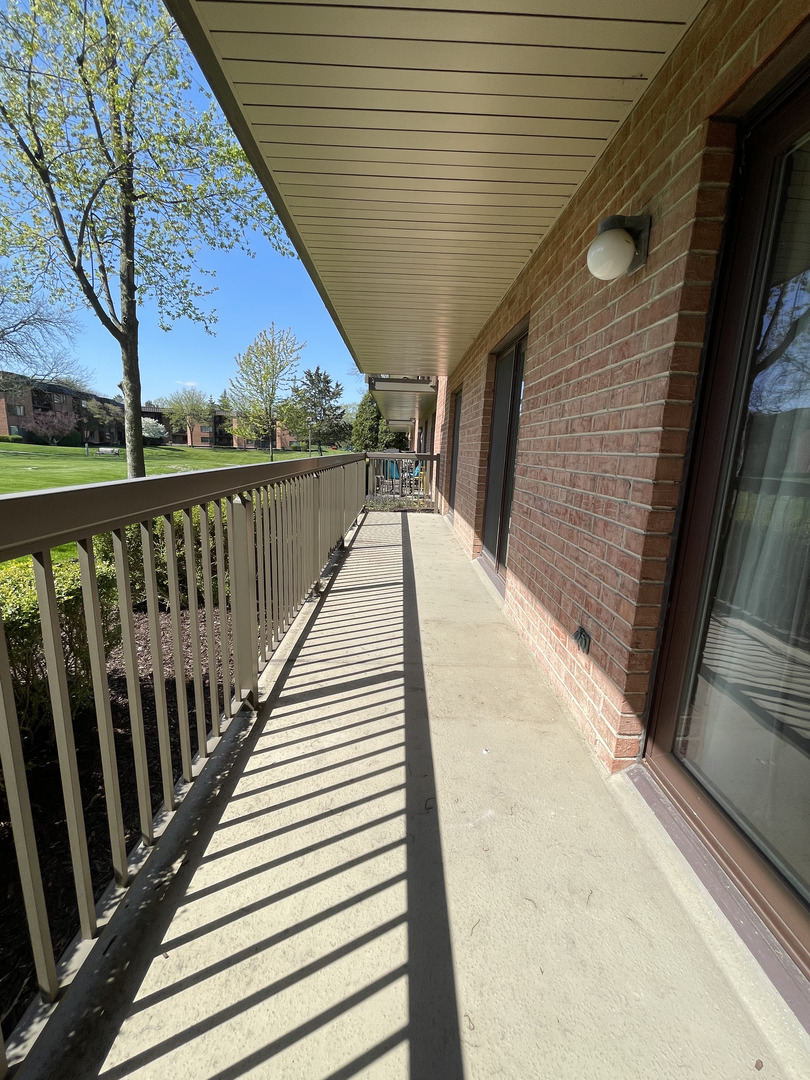 6443 Clarendon Hills Road, Unit 107 Willowbrook, IL 60527 - Photo 15 of 19 a view of balcony with wooden floor and fence