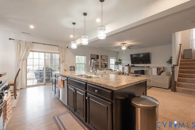 a kitchen with stainless steel appliances granite countertop a sink a stove and a refrigerator