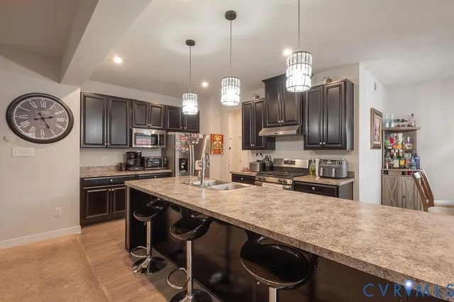 a kitchen with stainless steel appliances granite countertop a stove a refrigerator and a sink