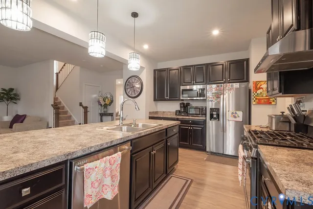 a kitchen with granite countertop a sink a counter space appliances and living room view