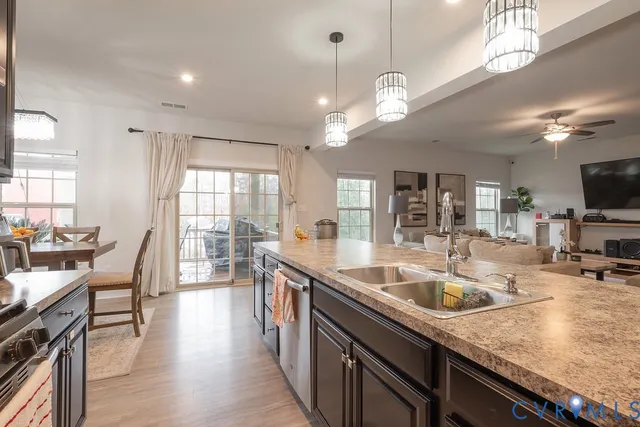 a kitchen with stainless steel appliances granite countertop a stove a sink dishwasher and cabinets with wooden floor