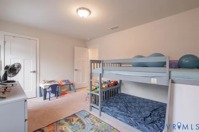 a bedroom with a bed and a flat tv screen on the dresser