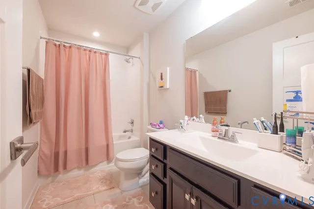 a bathroom with a double vanity sink a mirror and a bathtub