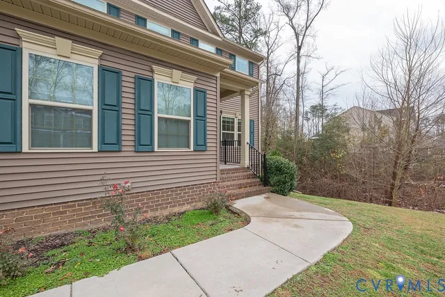 a view of a house with a yard and potted plants