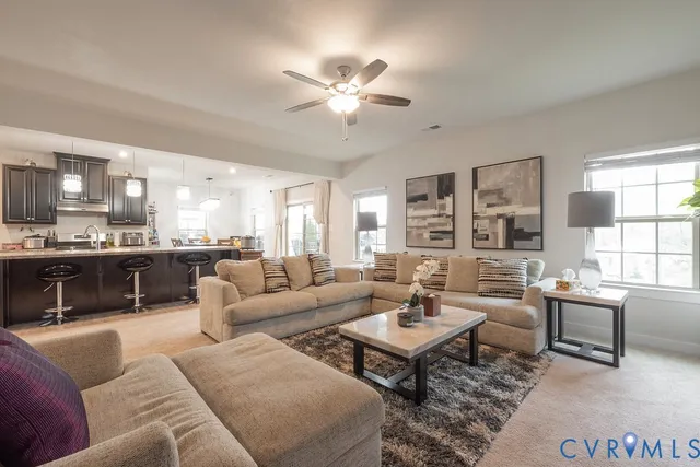 a living room with furniture kitchen view and a large window