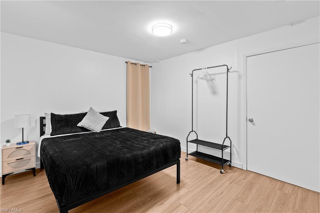 3303 6th Street Southwest Lehigh Acres, FL 33976 - Photo 11 of 23 a bedroom with a bed and wooden floor