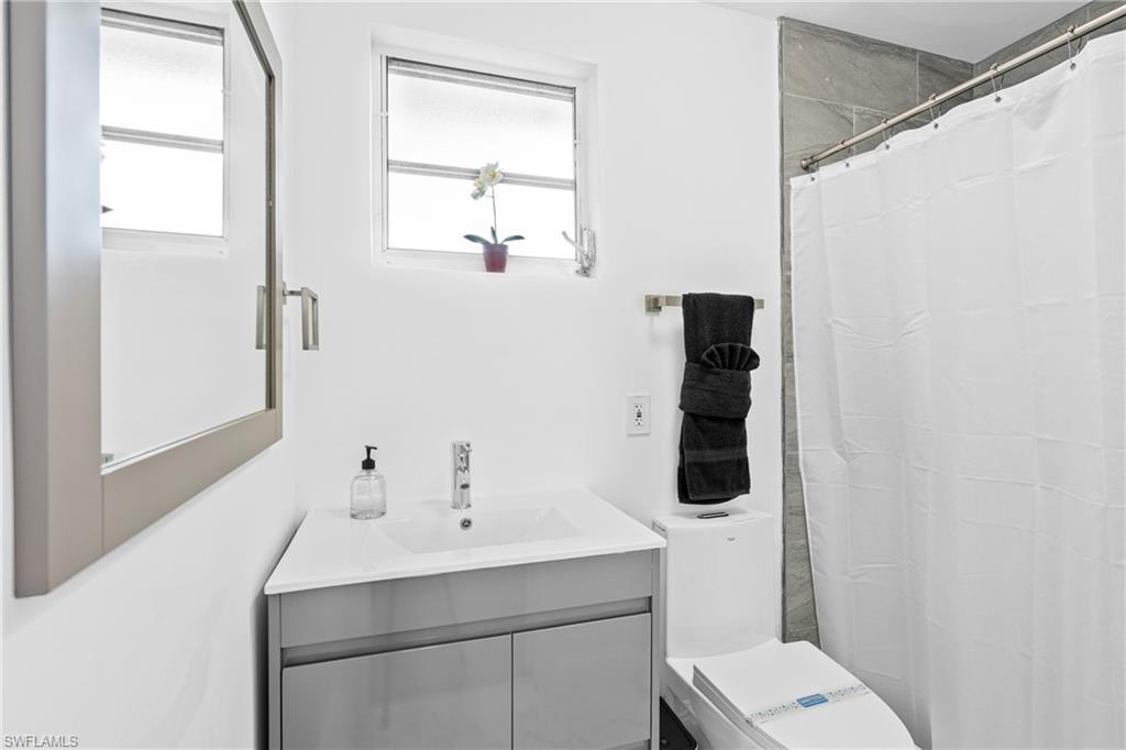 3303 6th Street Southwest Lehigh Acres, FL 33976 - Photo 15 of 23 a bathroom with a sink toilet and mirror