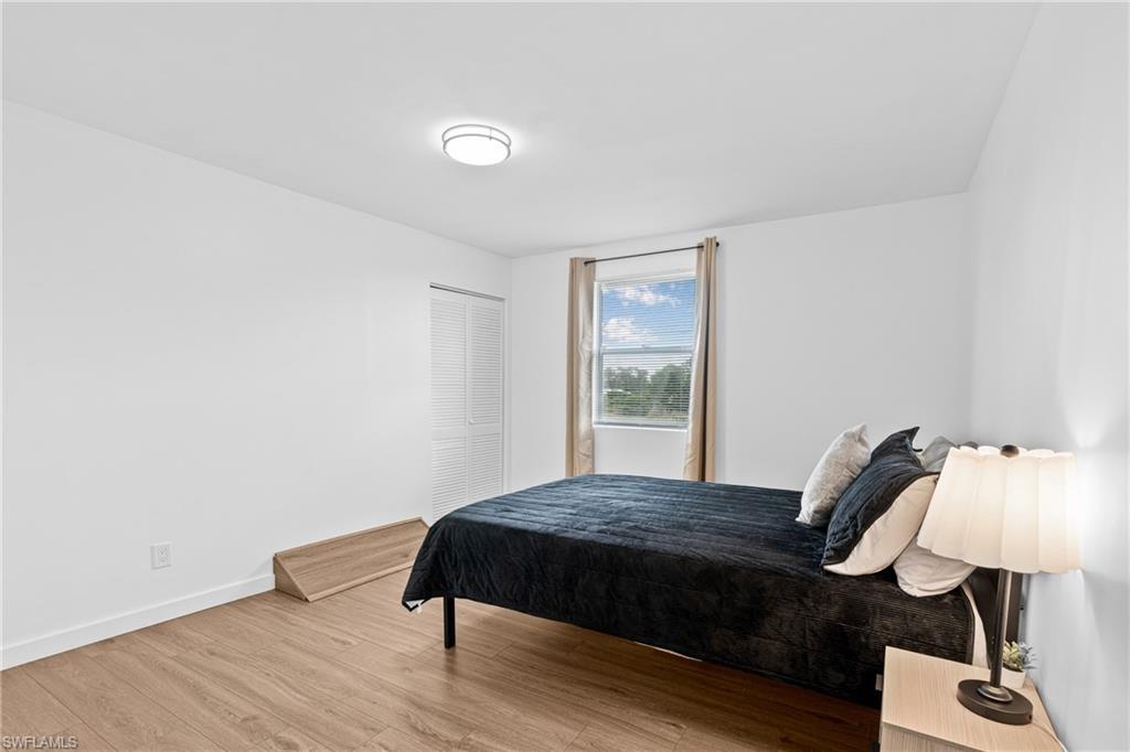3303 6th Street Southwest Lehigh Acres, FL 33976 - Photo 16 of 23 a bedroom with a bed window and a lamp